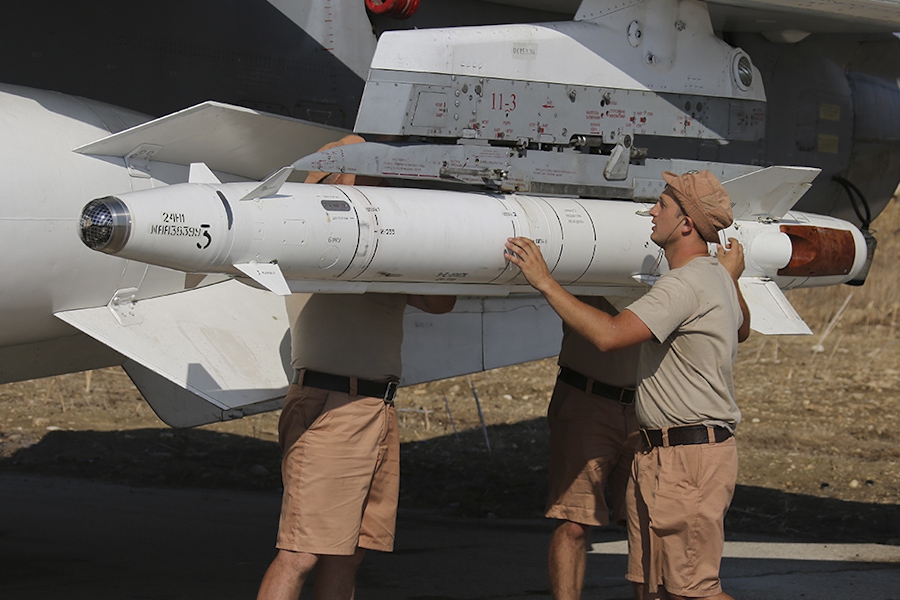 Rosyjscy żołnierze montują rakiety na samolot wojskowy w Syrii